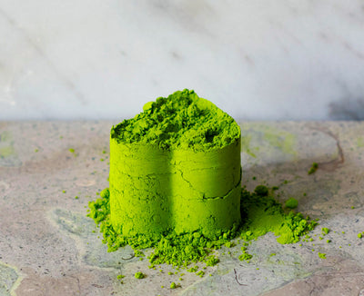 Heart-shaped pile of beautiful matcha, Blend Daphne, sitting on granite. 