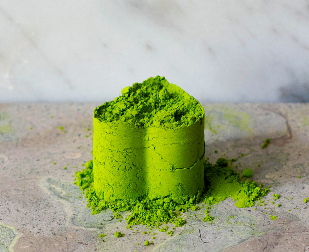 Heart-shaped pile of beautiful matcha, Blend Daphne, sitting on granite. 